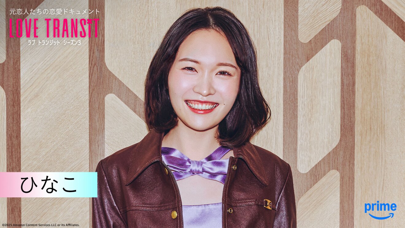 木目調の壁の前に立つ人物のバストアップ。光沢のあるワイン色のジャケット。左上隅に「LOVE TRANSIT」の文字。左下に「ひなこ」と名前が表示されている。