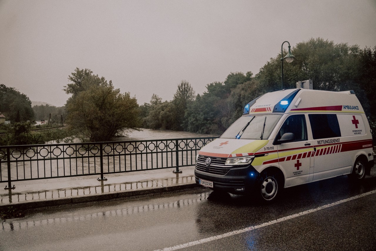 Ein Bild von einem Rettungswagen neben einem Hochwassergebiet.
