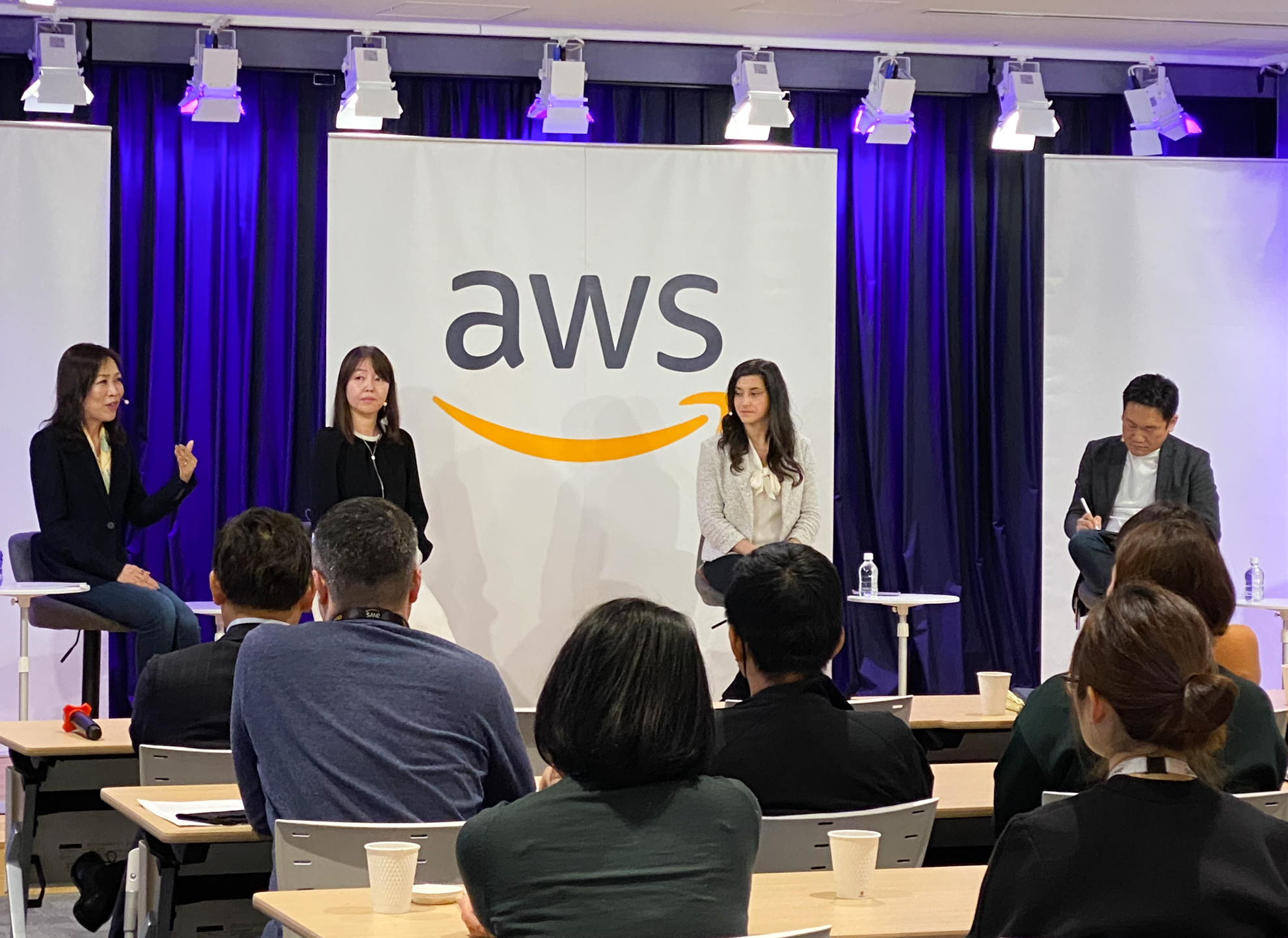 AWSが開催したIWDのためのイベント 男性1人と女性3人がステージでトークセッションを行っている
