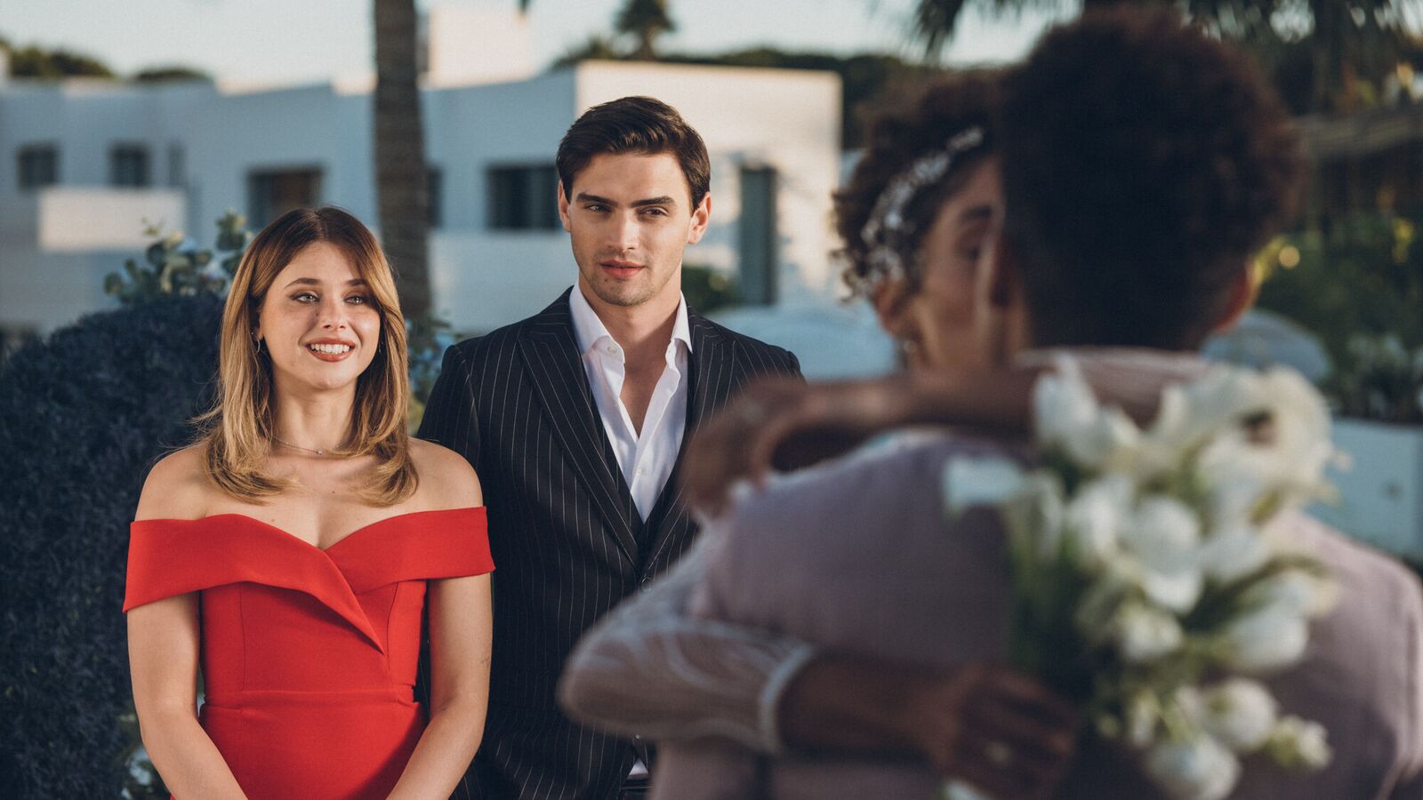 Culpa Nuestra: A man and a woman look at a couple at a wedding