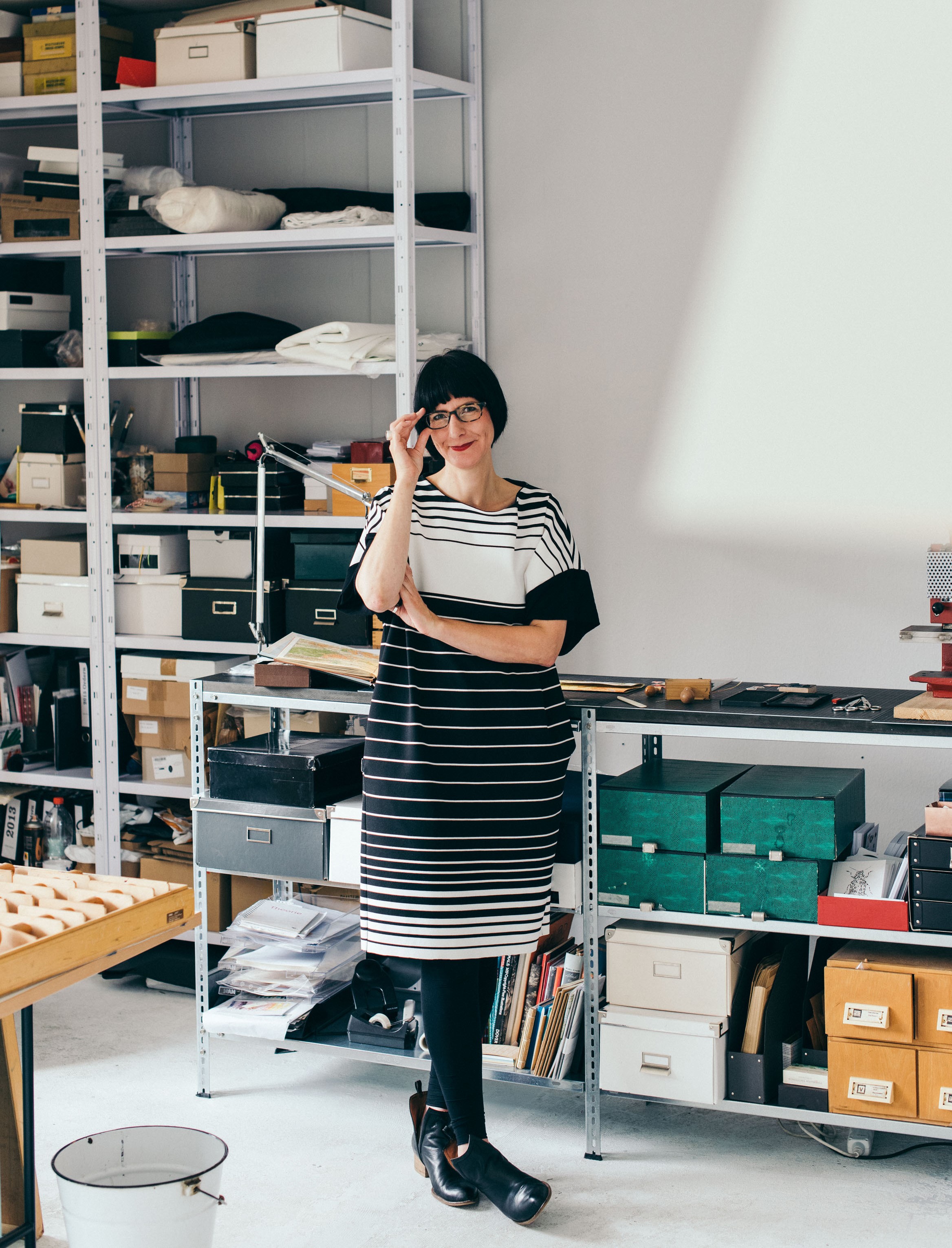 Christiane Hübner von renna deluxe in ihrer Werkstatt. Im Hintergrund sieht man Regale mit Kisten.