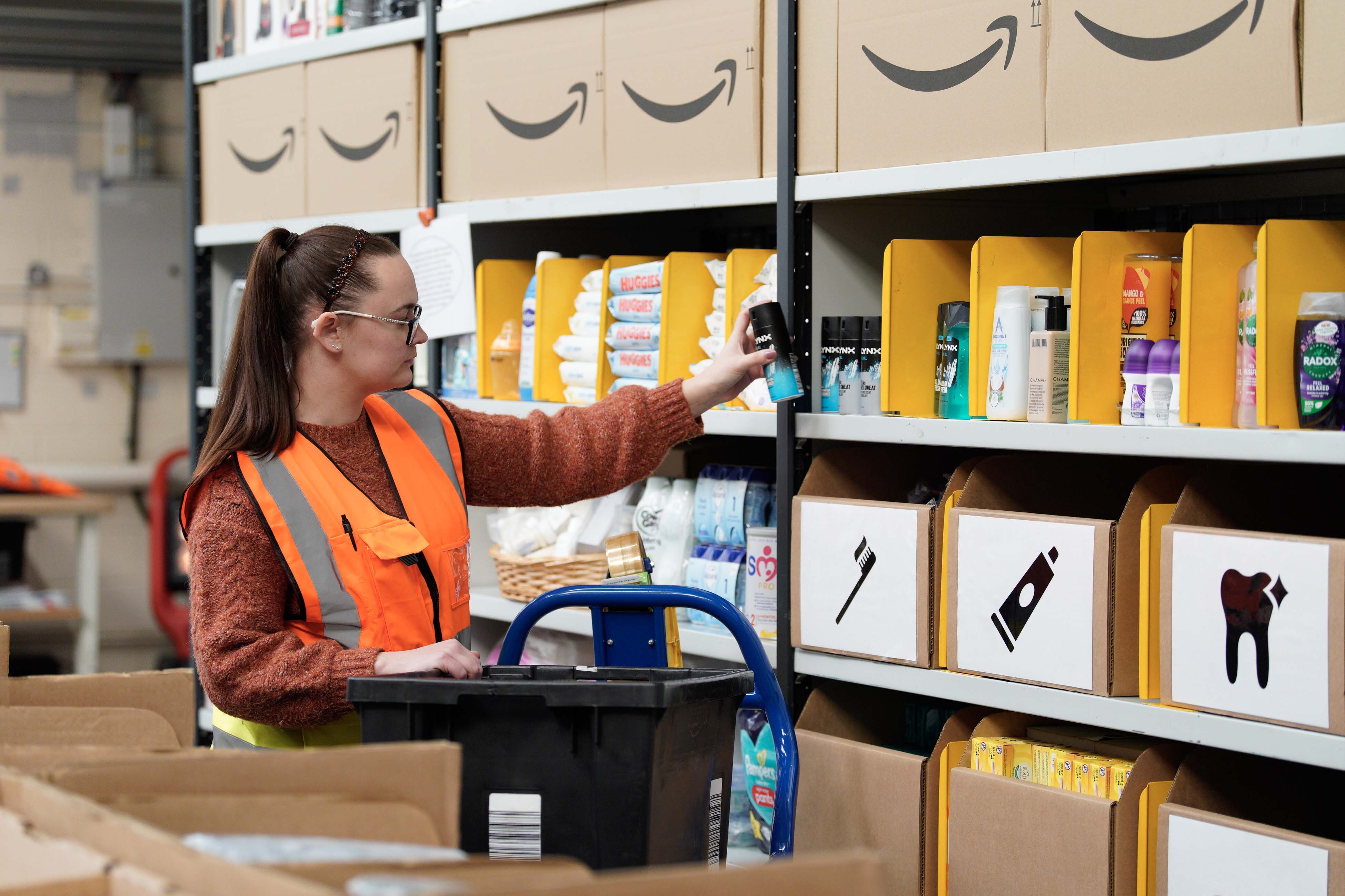 A volunteer stocks shelves at the newest Amazon Multibank in Swansea