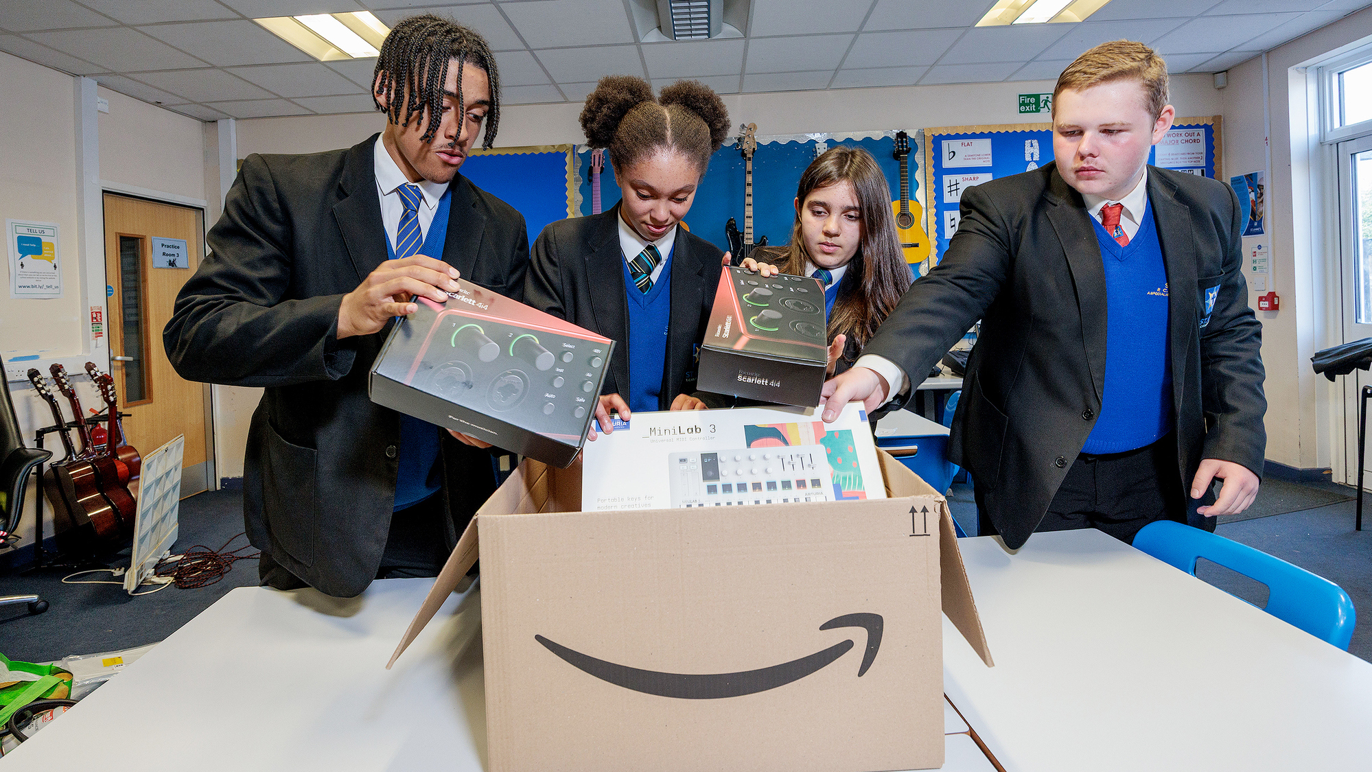 Four St Annes School, Stockport students pull music technology out from an Amazon parcel.