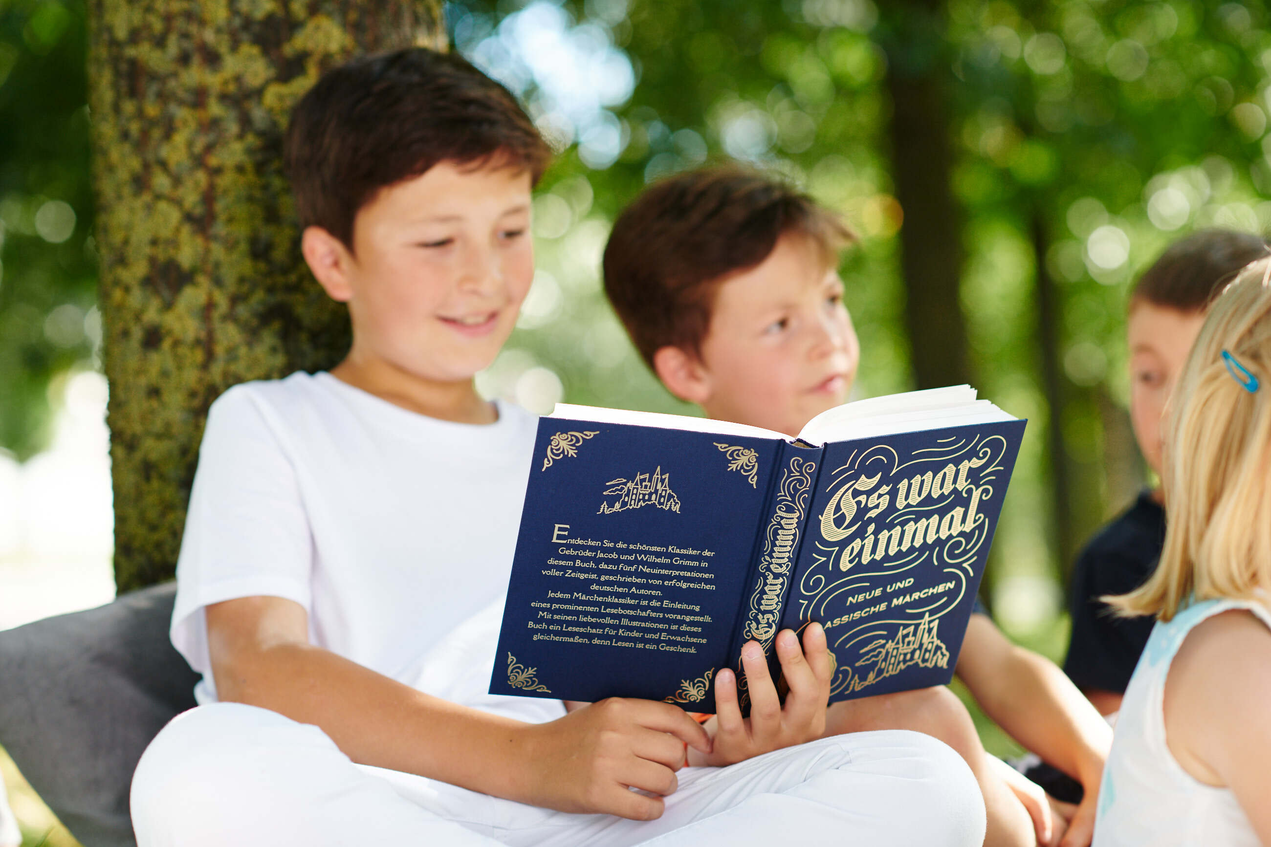 Kind liest aus Märchenbuch "Es war einmal"