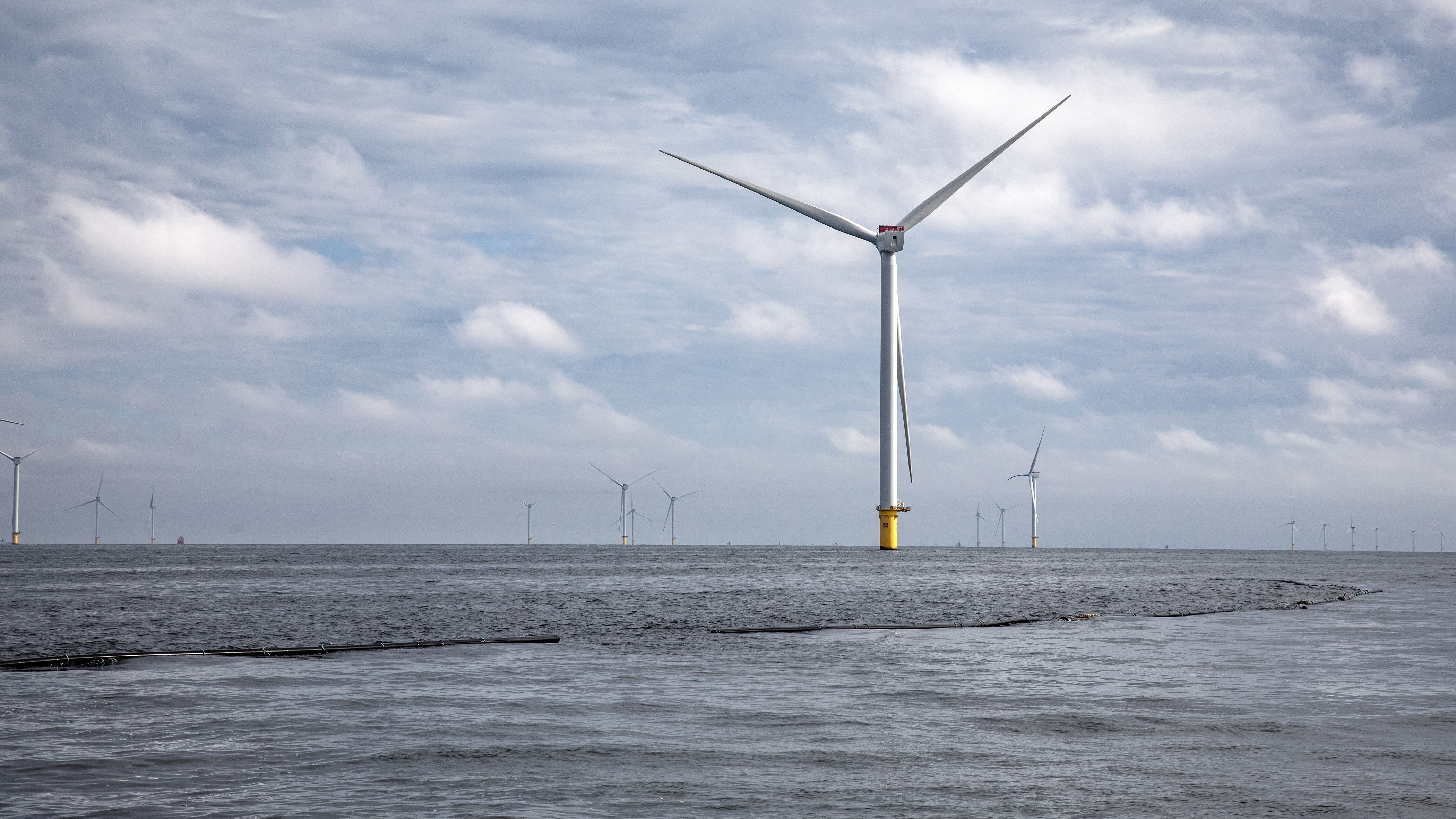 Offshore wind farm with turbines stretching across a cloudy seascape