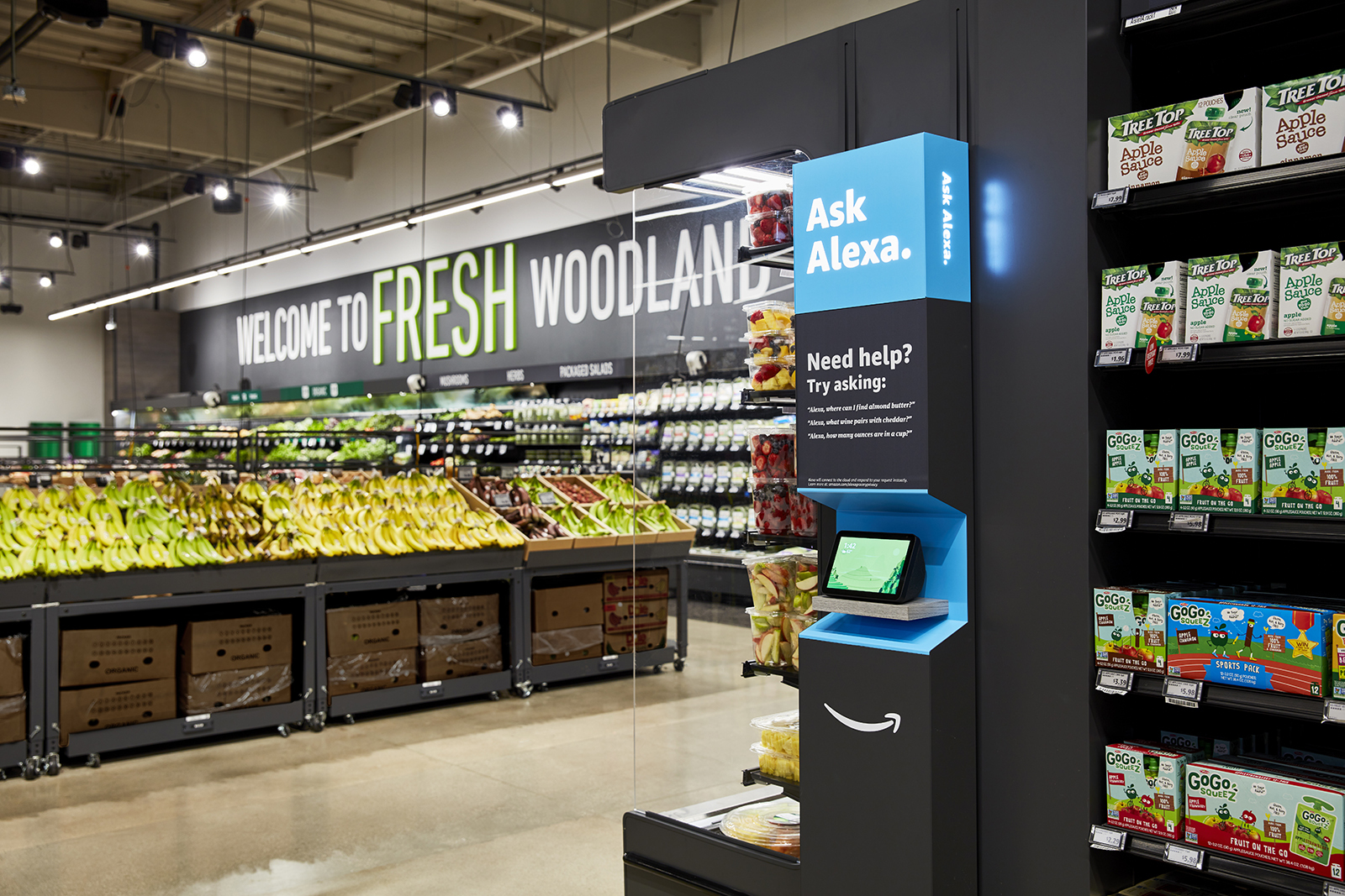 An image of the Amazon Fresh grocery store in Woodland Hills. It shows produce in the background and an Al;exa feature in the foreground.