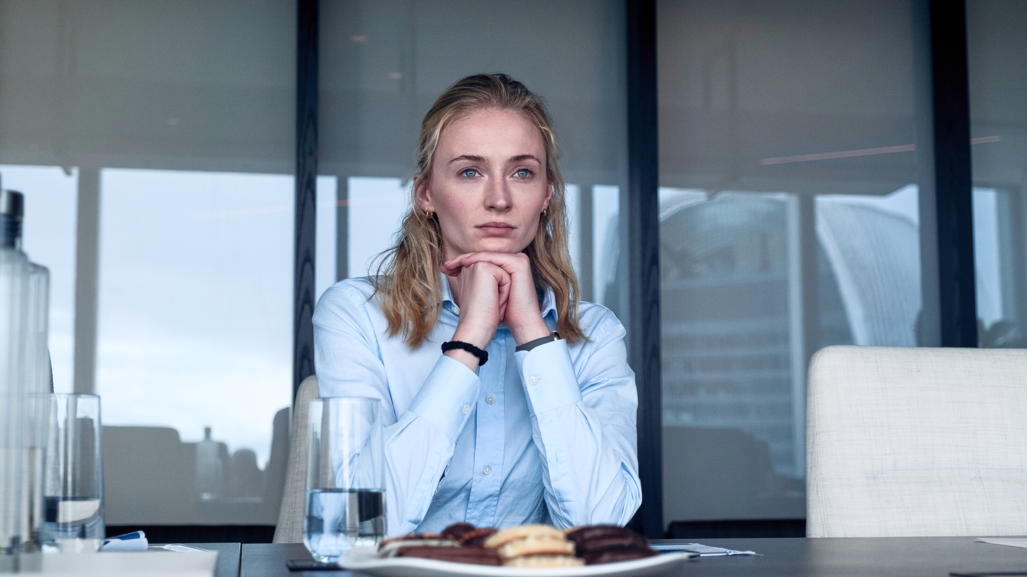 Pensive woman in light blue shirt at conference table